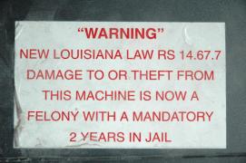 "WARNING"/New Louisiana Law RS 14.67.7/Damage to or theft from this machine is now a felony with a mandatory 2 years in Jail/This sticker from a soft drink vending machine in a hotel decorated my VCR vor many years